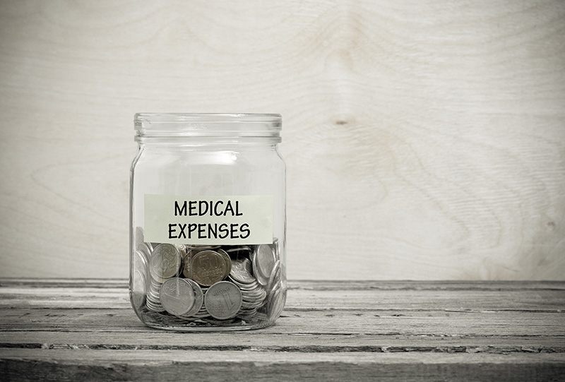 Medical Expenses written on a jar with coins in it