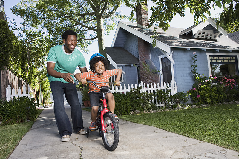 Man Helping Boy Learn to Ride a Bike