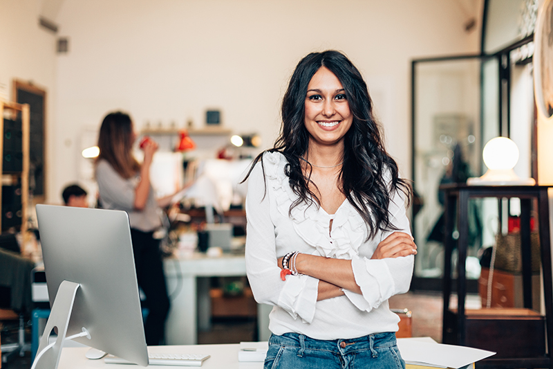 Woman Standing by her Desk in an Office